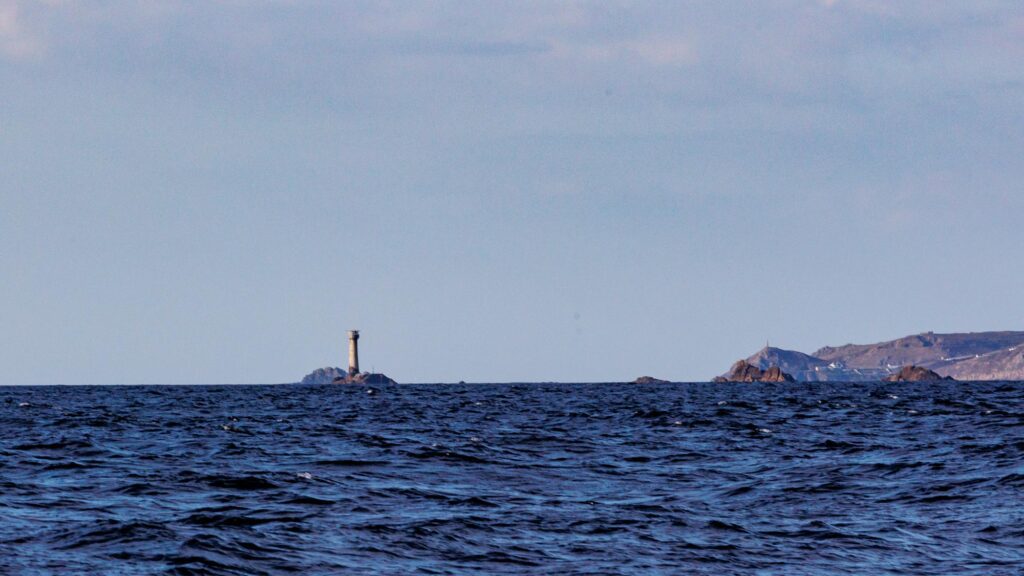 Divided in two, the image shows sea and sky with a lighthouse on the horizon with rocks extending to the right where the connect with a headline. 