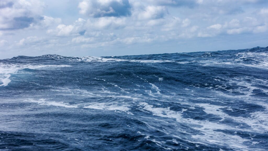 The image shows sea with a 1-2m swell running and wind blown foam coming off the top of the waves