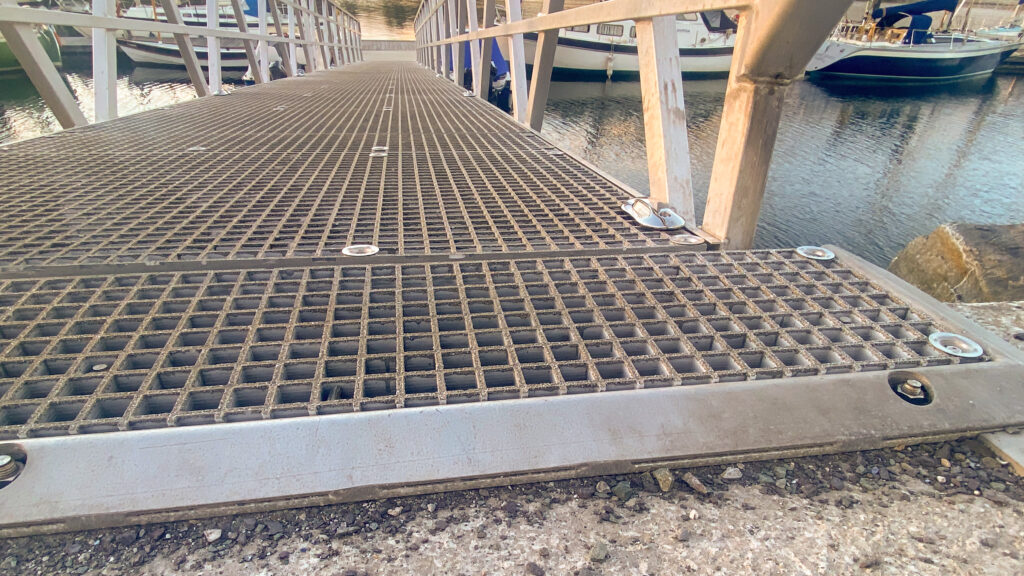 Shows an excellent wide, marina gangway with high friction surface that has been kept clear of algae.