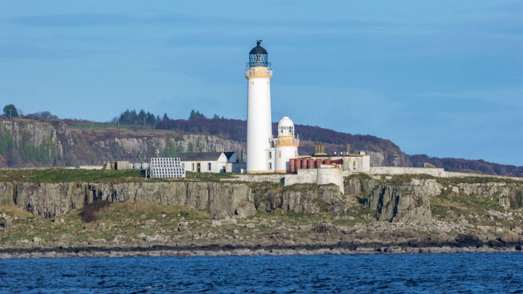 Pladda Lighthouse stands a white and ochre pillar on a basalt column island