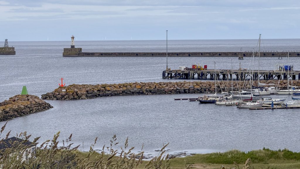 A nineteenth century harbour breakwater with a. large enclosed harbour and a marina in the bottom right hand corner
